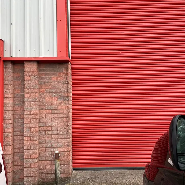 Before and after of a wicket gate being fitted into an existing roller shutter (Motor Garage in Dudley)