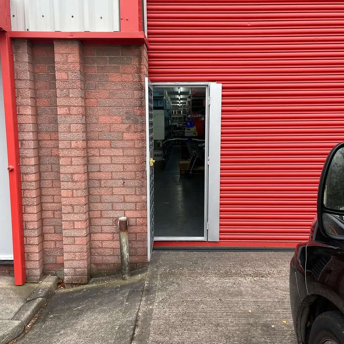 Before and after of a wicket gate being fitted into an existing roller shutter (Motor Garage in Dudley)